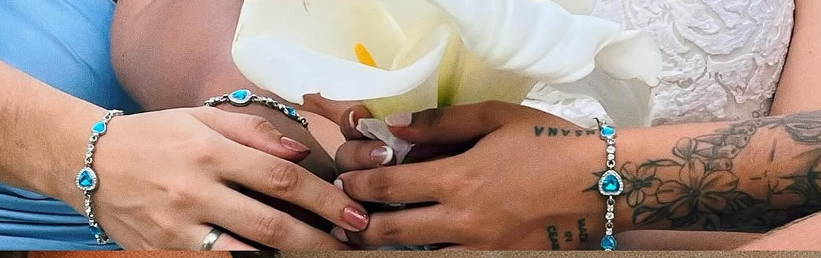 Mãos dos noivos sobre a flor